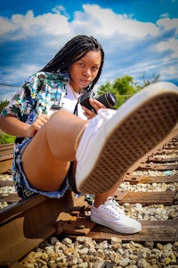 a woman is taking a picture of her feet on a train track